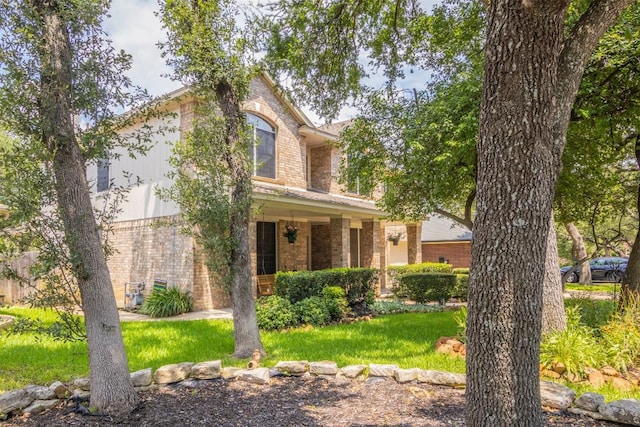 traditional home featuring brick siding and a front yard