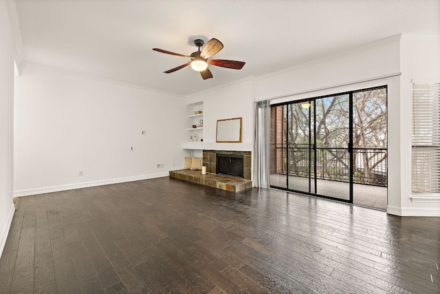 unfurnished living room with crown molding, dark wood-style floors, and a tile fireplace