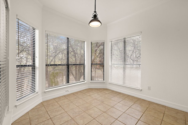 spare room with light tile patterned floors, baseboards, a healthy amount of sunlight, and ornamental molding