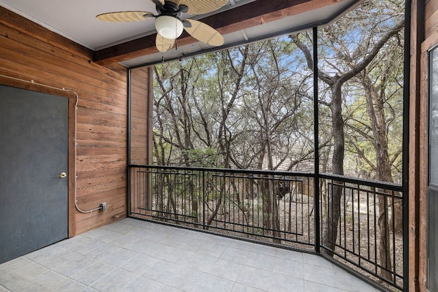 unfurnished sunroom featuring ceiling fan