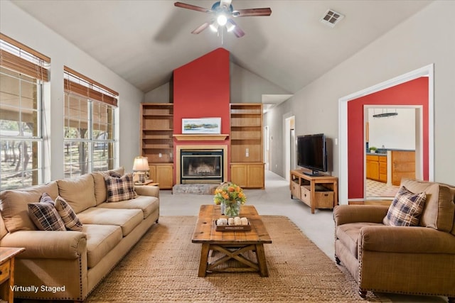 living room featuring visible vents, ceiling fan, light colored carpet, lofted ceiling, and a glass covered fireplace