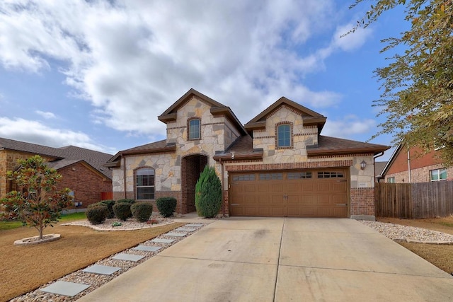 view of front of house with fence, concrete driveway, a garage, stone siding, and brick siding