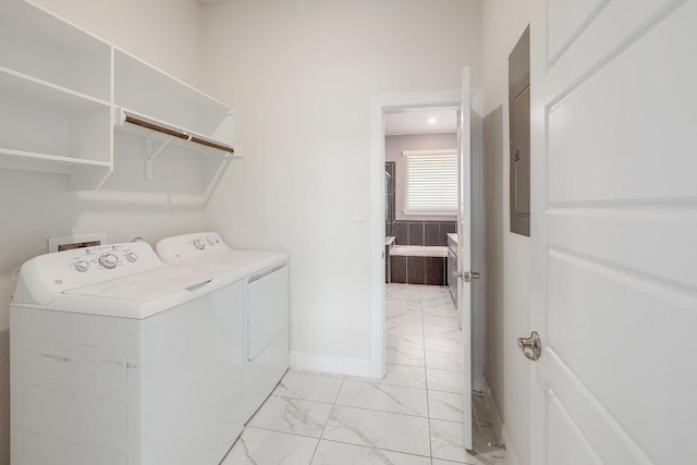 clothes washing area with laundry area, separate washer and dryer, marble finish floor, and baseboards