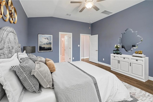 bedroom featuring lofted ceiling, baseboards, visible vents, and dark wood-style flooring