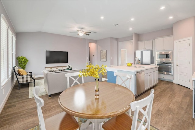 dining room with ceiling fan, baseboards, vaulted ceiling, recessed lighting, and light wood-style floors