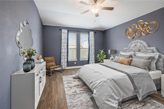 bedroom with ceiling fan, baseboards, wood finished floors, and vaulted ceiling