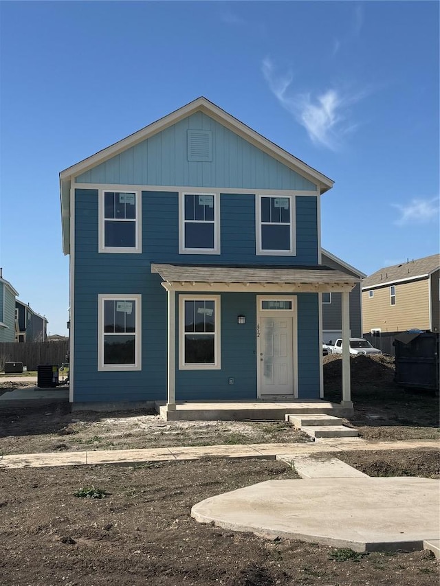 view of front of property featuring board and batten siding, central air condition unit, fence, and covered porch