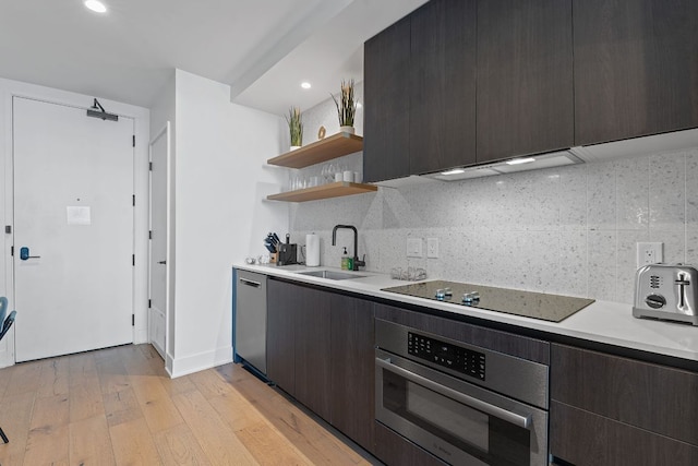 kitchen with open shelves, a sink, oven, light countertops, and black electric stovetop