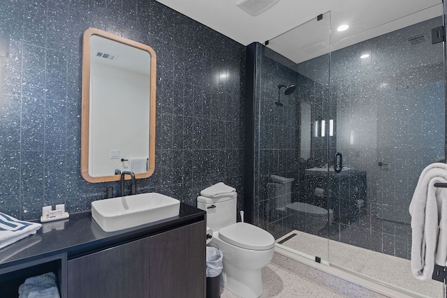 bathroom featuring visible vents, toilet, a stall shower, speckled floor, and vanity