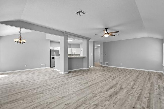 unfurnished living room with visible vents, baseboards, light wood-type flooring, vaulted ceiling, and ceiling fan with notable chandelier