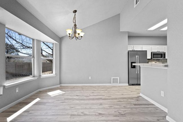 unfurnished dining area featuring light wood-type flooring, visible vents, baseboards, and a notable chandelier