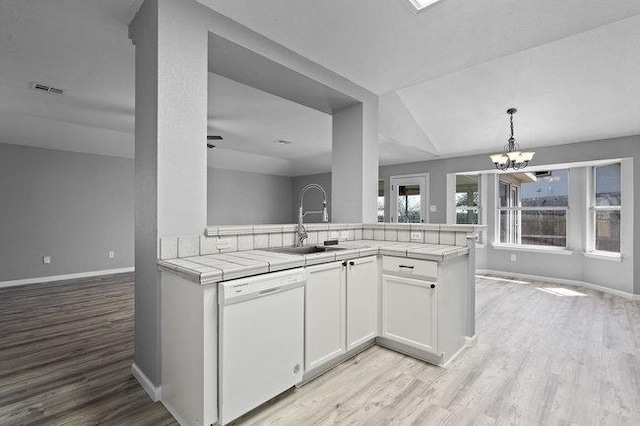 kitchen with open floor plan, tile countertops, dishwasher, and light wood-style floors