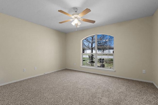 carpeted spare room with baseboards and ceiling fan