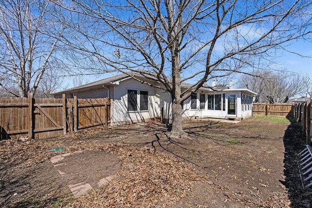 exterior space featuring brick siding and a fenced backyard