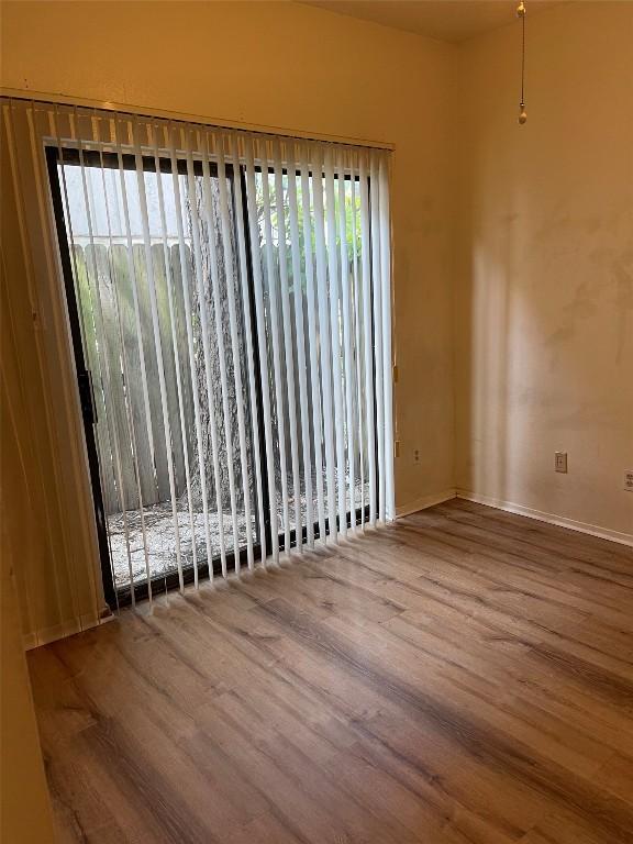 empty room with a wealth of natural light and wood finished floors