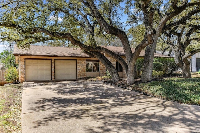 view of front of house with a garage, stone siding, and driveway