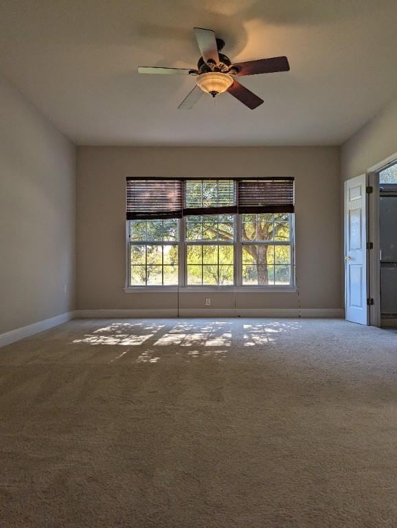 interior space with baseboards, carpet floors, and ceiling fan