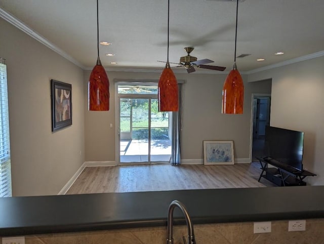 kitchen featuring visible vents, crown molding, baseboards, recessed lighting, and wood finished floors