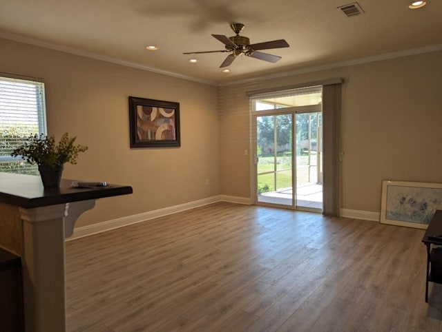 interior space with a wealth of natural light, visible vents, and crown molding