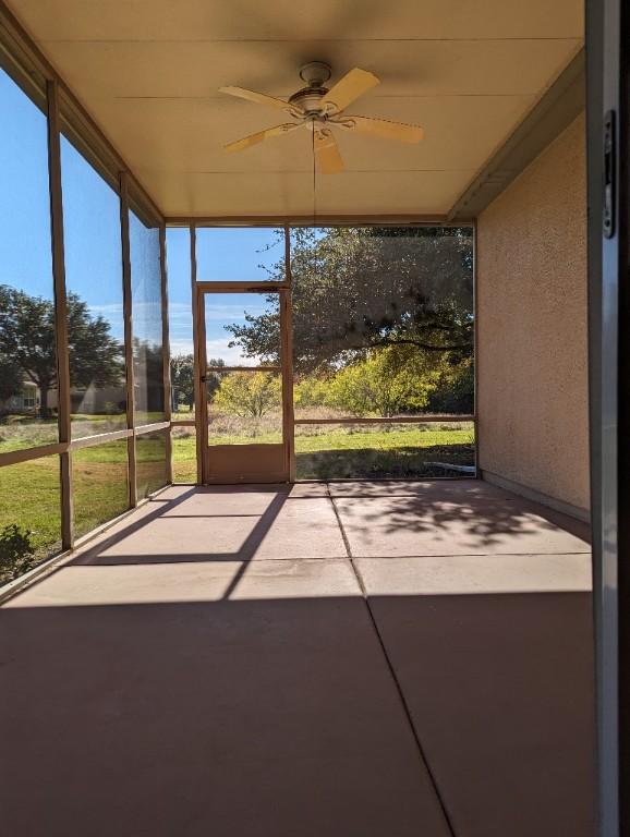 unfurnished sunroom with ceiling fan