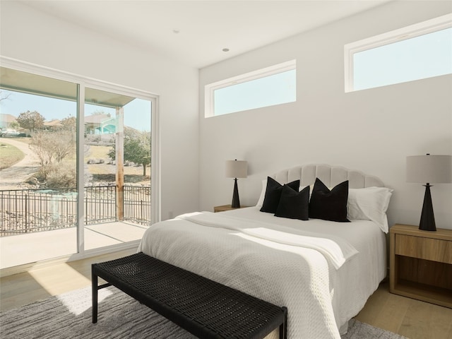 bedroom with access to outside and light wood-type flooring