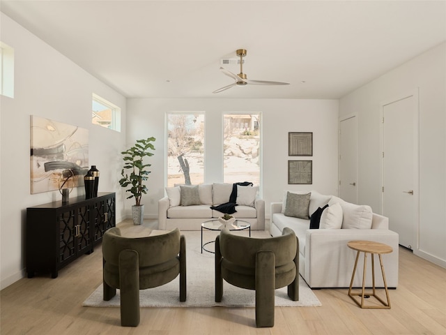 living area with visible vents, baseboards, light wood-type flooring, and ceiling fan