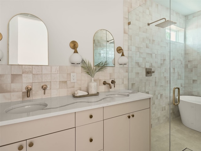 full bath with tile walls, double vanity, a shower stall, and a sink