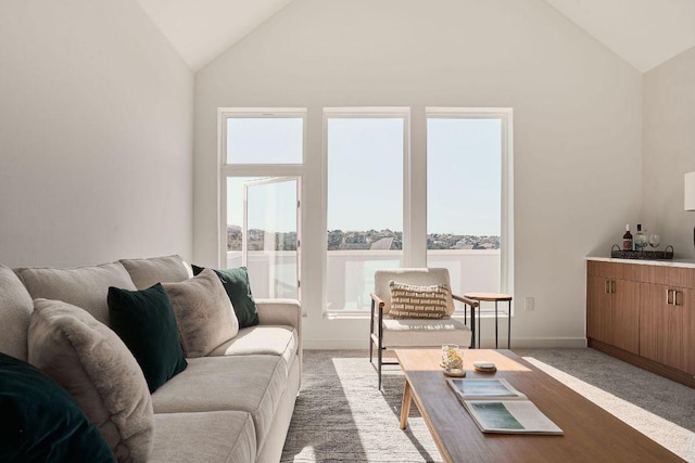 living room featuring baseboards, light colored carpet, and high vaulted ceiling