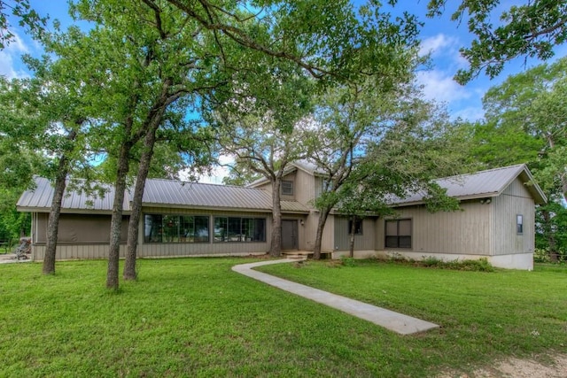 exterior space featuring metal roof and a front lawn