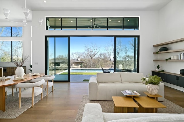 living room with wood finished floors and a towering ceiling