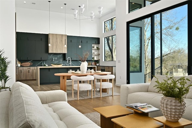 living room featuring a chandelier, wood finished floors, and a towering ceiling