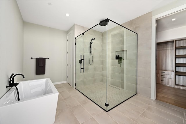 bathroom with tile patterned flooring, a shower stall, recessed lighting, and a freestanding bath