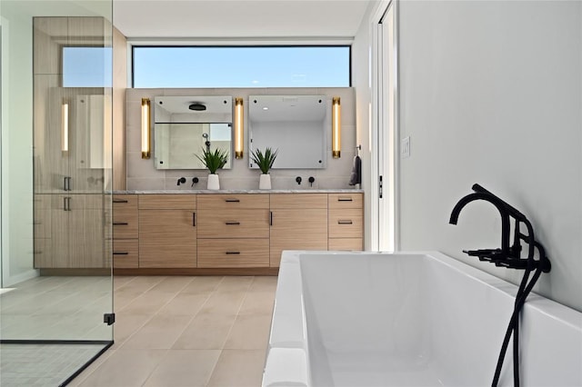 bathroom featuring double vanity, plenty of natural light, a sink, a shower stall, and tile patterned floors