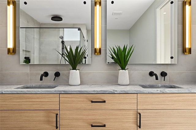 full bath with decorative backsplash, double vanity, and a sink