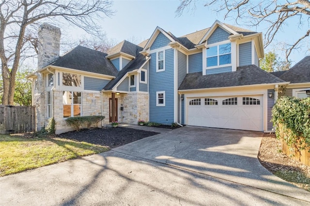 view of front of home with fence, a garage, driveway, and a chimney