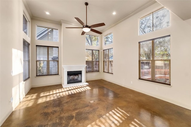 unfurnished living room featuring a towering ceiling, a fireplace with raised hearth, finished concrete flooring, and crown molding