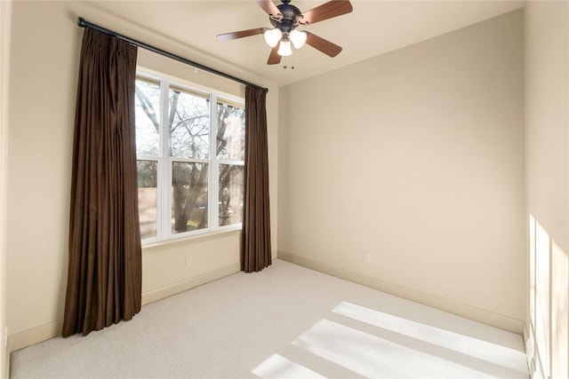 empty room featuring baseboards, carpet, and a ceiling fan