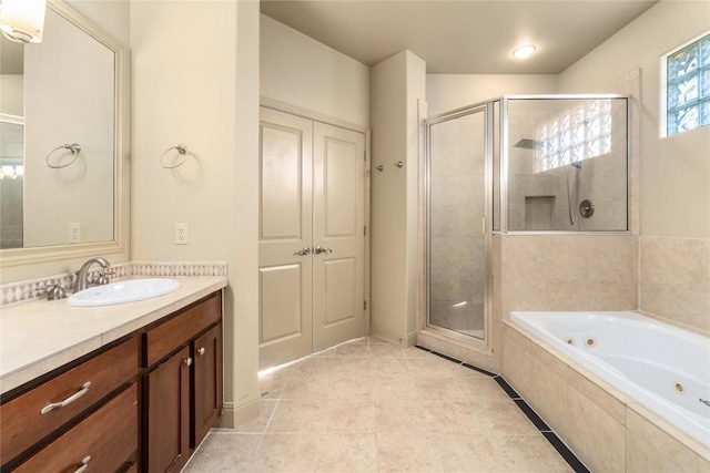 bathroom featuring tile patterned floors, a tub with jets, a shower stall, and vanity