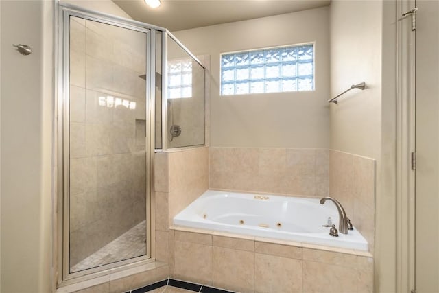 bathroom featuring a wealth of natural light, a stall shower, and a whirlpool tub