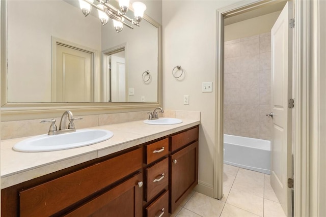 full bath featuring tile patterned floors, a notable chandelier, double vanity, and a sink