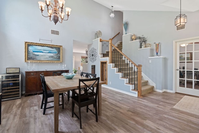 dining space featuring stairs, wine cooler, wood finished floors, and visible vents