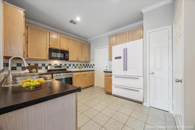 kitchen featuring visible vents, freestanding refrigerator, a sink, black microwave, and stainless steel gas stove