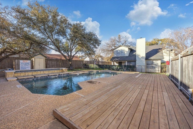 view of pool featuring a fenced backyard, a storage shed, an outdoor structure, a wooden deck, and a fenced in pool