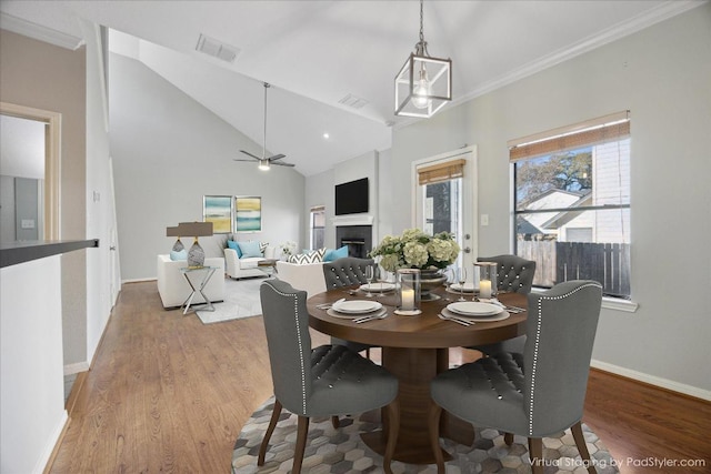 dining area with visible vents, baseboards, wood finished floors, and a fireplace