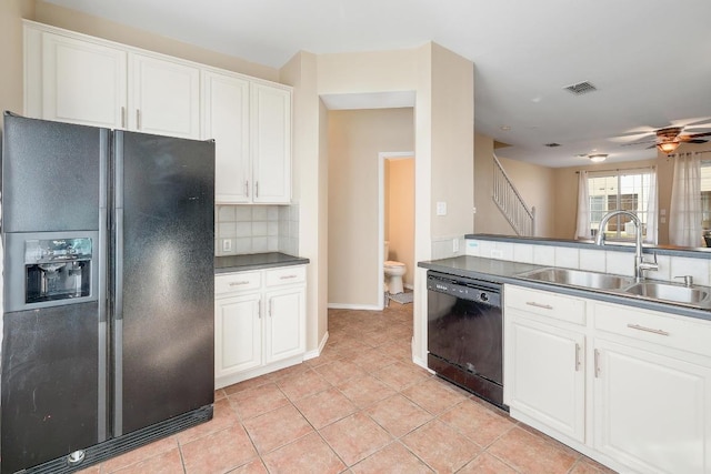 kitchen featuring light tile patterned floors, a sink, decorative backsplash, black appliances, and white cabinetry