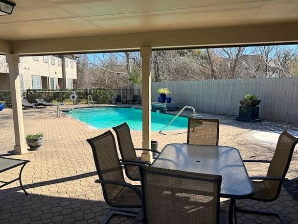 view of pool featuring outdoor dining space, a patio, a fenced backyard, and a fenced in pool