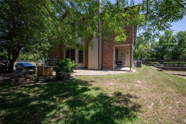 back of house with brick siding and central AC unit