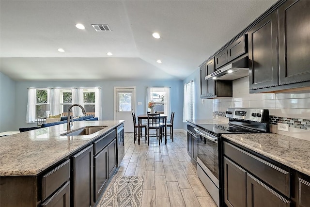 kitchen featuring visible vents, under cabinet range hood, vaulted ceiling, stainless steel appliances, and a sink