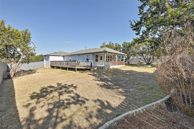 back of property with a wooden deck and a fenced backyard