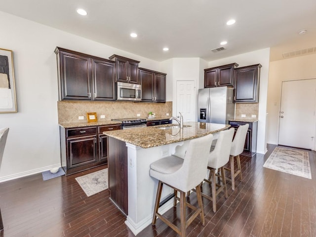 kitchen with visible vents, appliances with stainless steel finishes, a breakfast bar area, and a sink